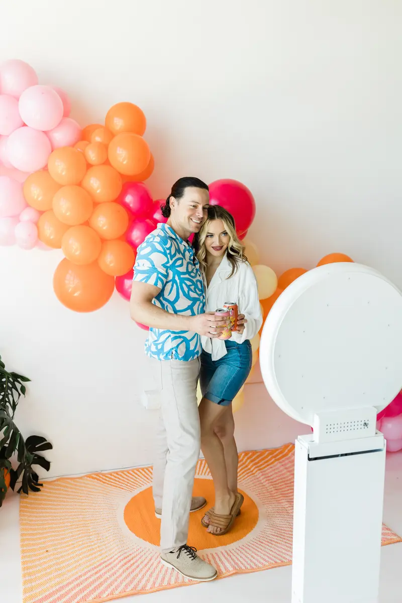 Guests laughing at a balloon wall photo booth. A photo booth setup we bring to San Diego events