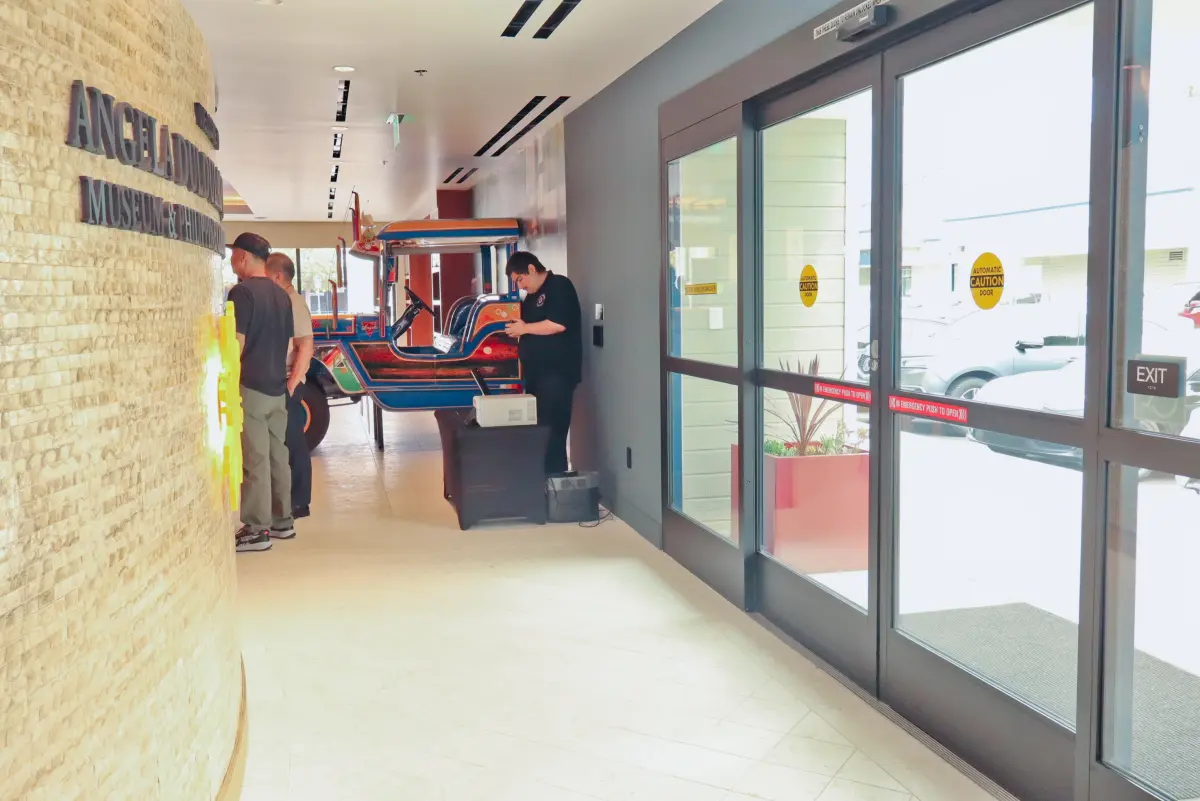 The Jeepney display and gallery walkway at the Angela Duldulao McPherson Museum in Port Hueneme, with the Captured Celebrations print station set up on a small table against the wall