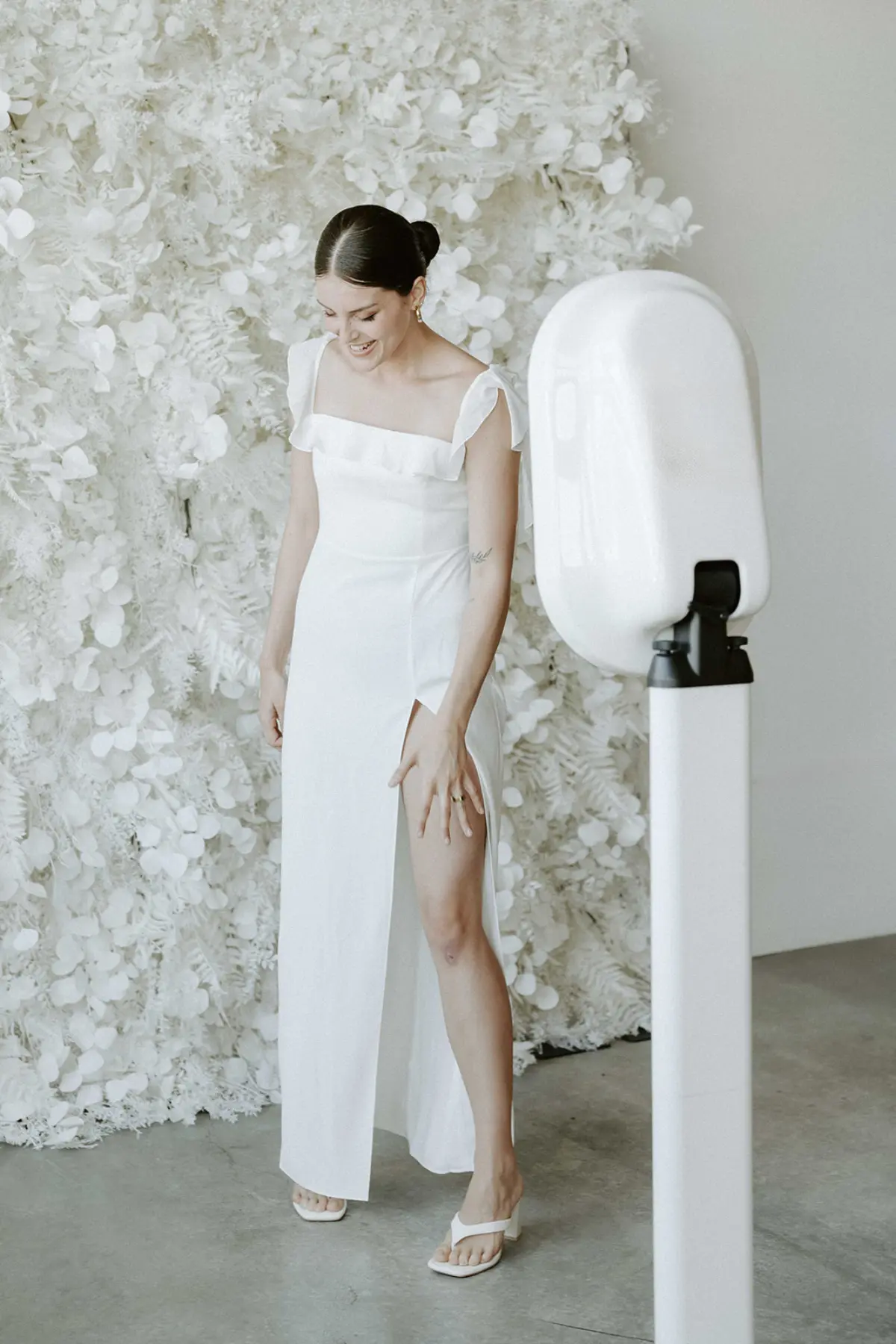 Open air photo booth with a white floral wall at a Los Angeles event