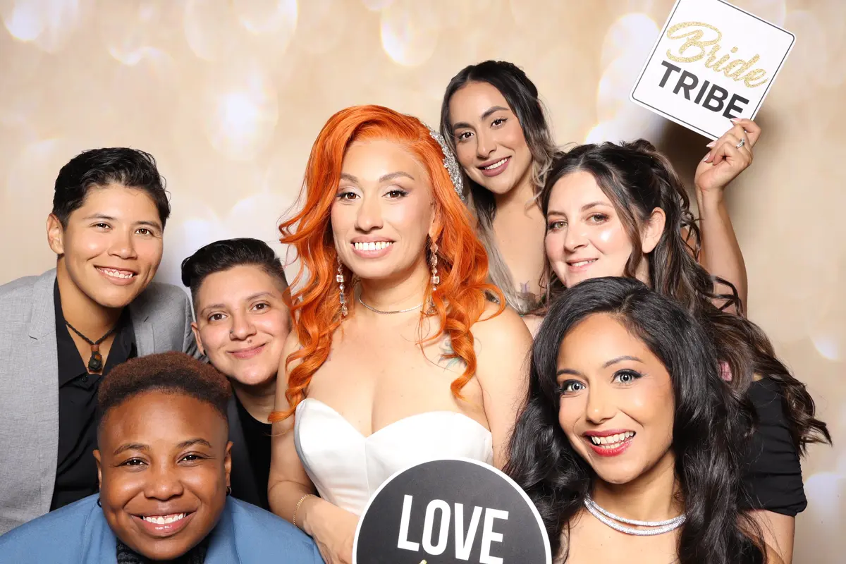 The bride and friends pose with a Bride Tribe sign at the Hart & Main wedding photo booth
