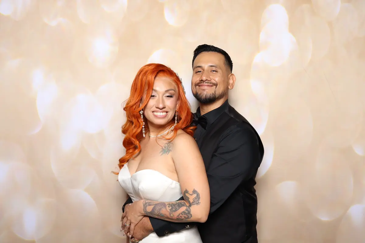 Bride Aley and groom Julian smile together at the wedding photo booth at Hart & Main in Santa Clarita