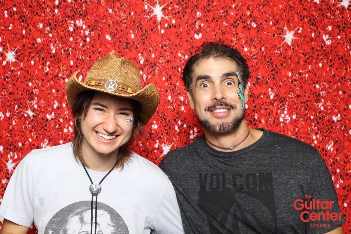 Guests with face paint posing at the Guitar Center branded photo booth print station, Red Ruby Sparkle backdrop, Thousand Oaks CA