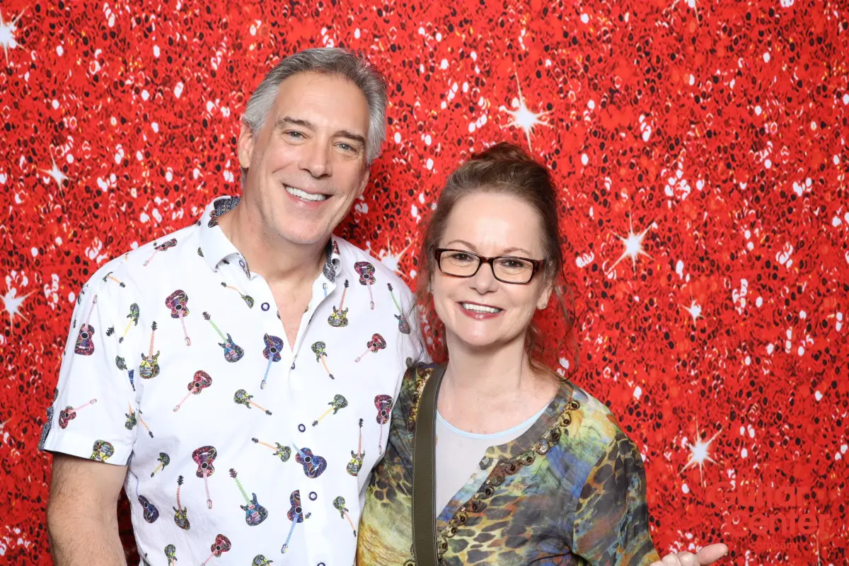 Two guests at the Captured Celebrations AI Print Booth in front of the Red Ruby Sparkle backdrop at Guitar Center Service Awards Jam Night, Tarantula Hill Brewing Company, Thousand Oaks CA