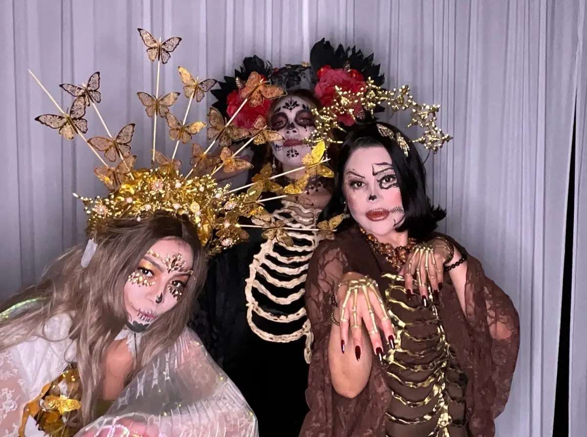 Guests in skeleton rib costumes and gold crowns at the Candela La Brea Day of the Dead photo booth