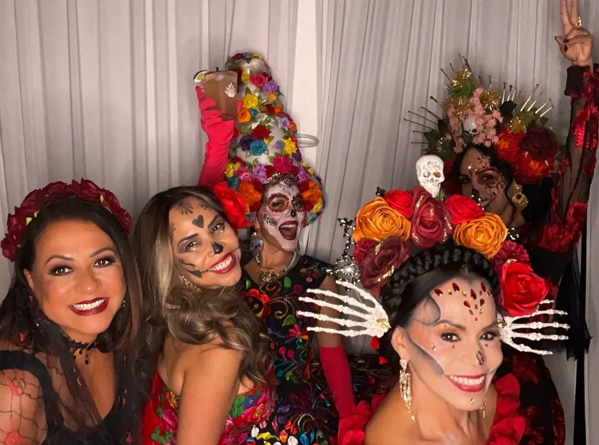 Group of five Catrinas in embroidered dresses and rose crowns at the Candela La Brea photo booth