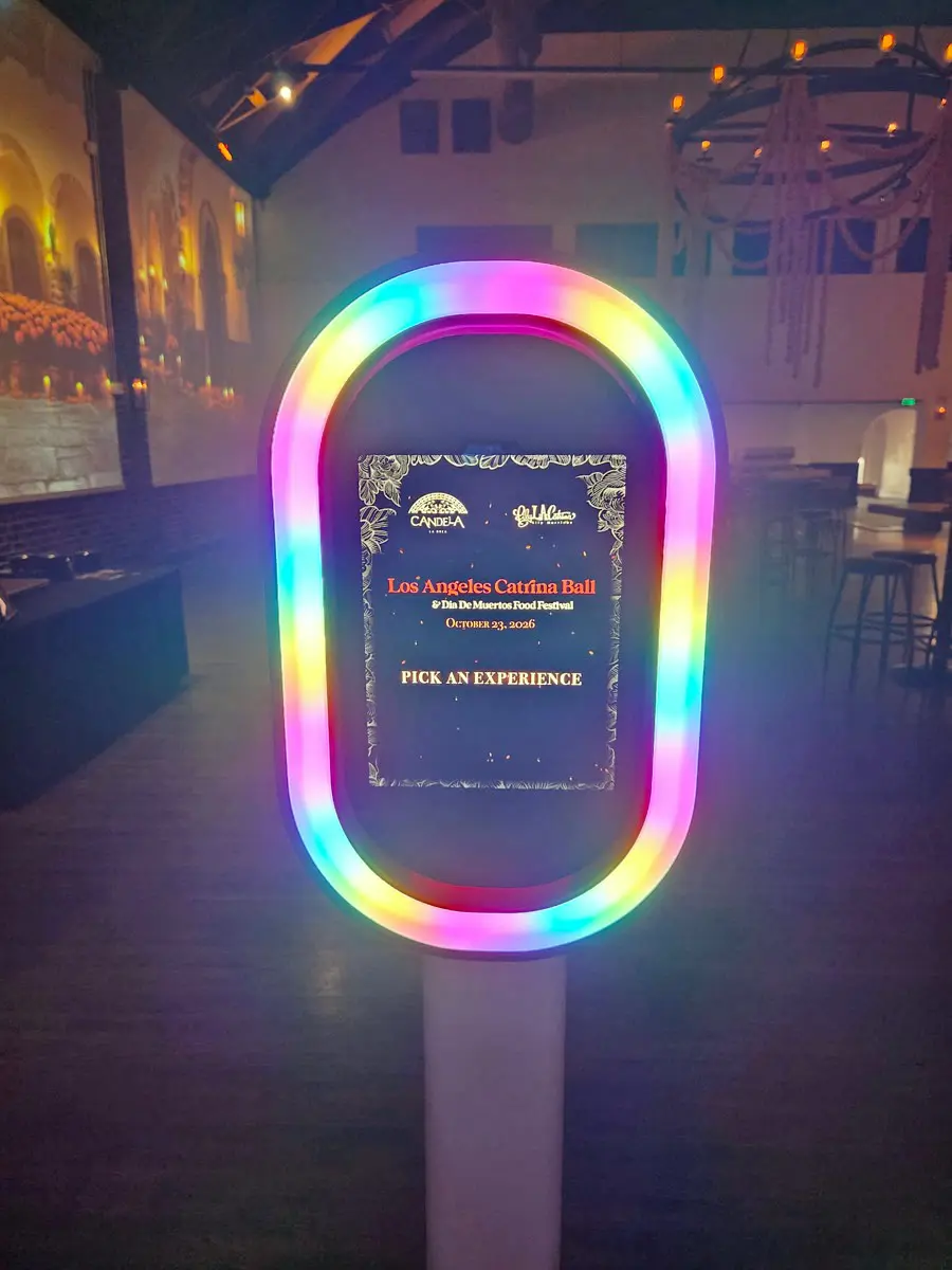 Photo booth with a rainbow LED ring showing the Los Angeles Catrina Ball start screen inside Candela La Brea in Los Angeles