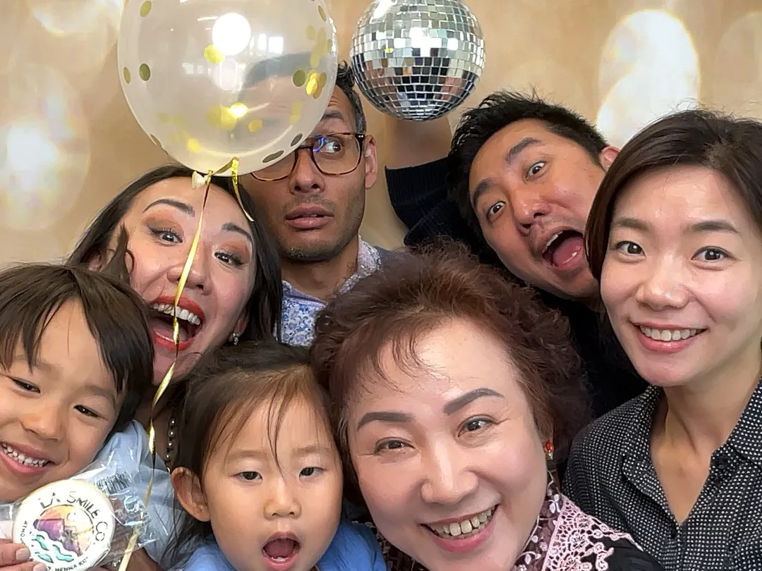 Family photo booth fun with balloons and disco ball